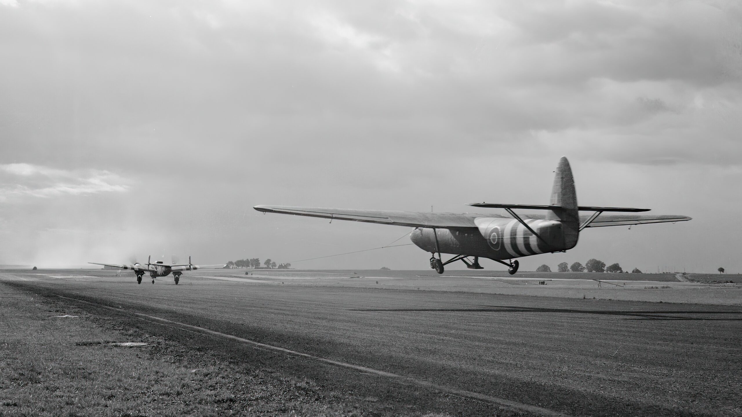 A Horsa glider carrying troops of 6th Airlanding Brigade is towed aloft by an Armstrong Whitworth Albemarle at an RAF airfield, part of 6th Airborne Division's second lift in the evening of June 6 1944