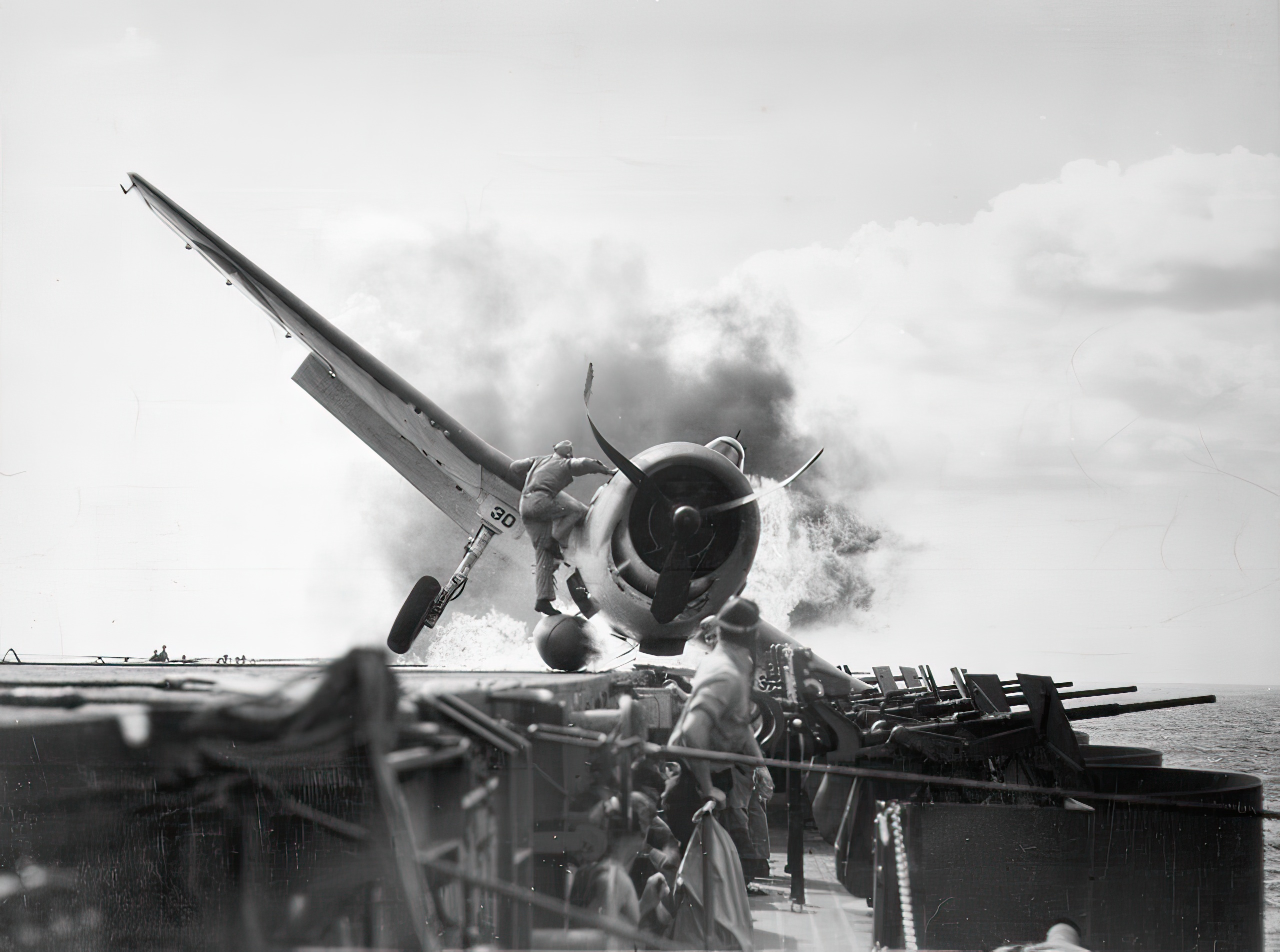 Crash landing of a U.S. Navy Grumman F6F-3 Hellcat (Number 30) of Fighting Squadron 2 (VF-2) aboard the aircraft carrier USS Enterprise (CV-6), into the carrier's port side 20mm gun gallery, November 10 1943